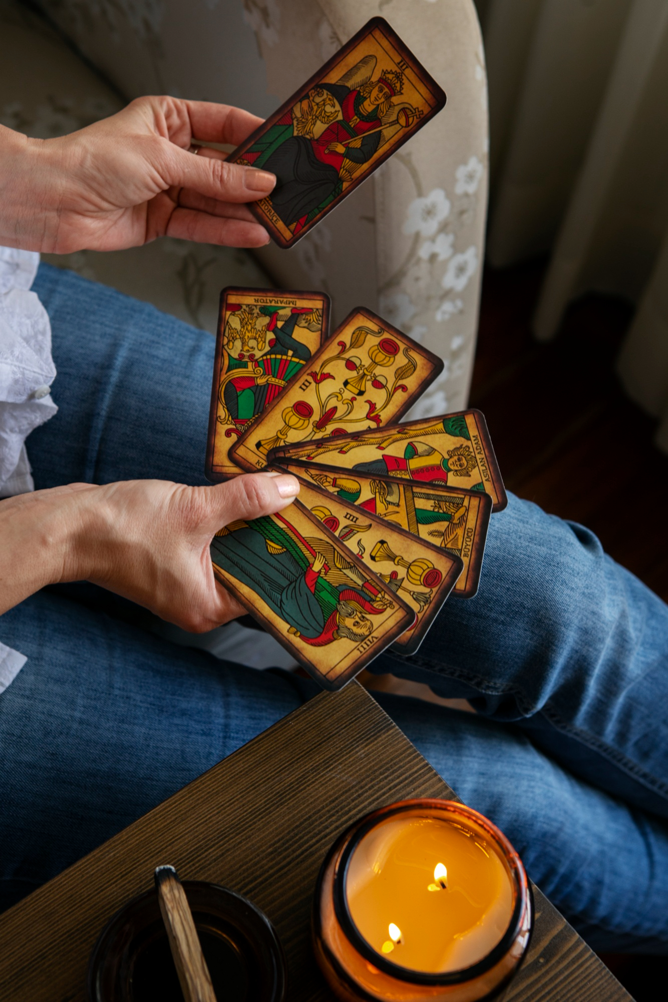 Pessoa analisando cartas de tarot durante leitura introspectiva, associada ao c&aacute;lculo do arcano pessoal e autoconhecimento