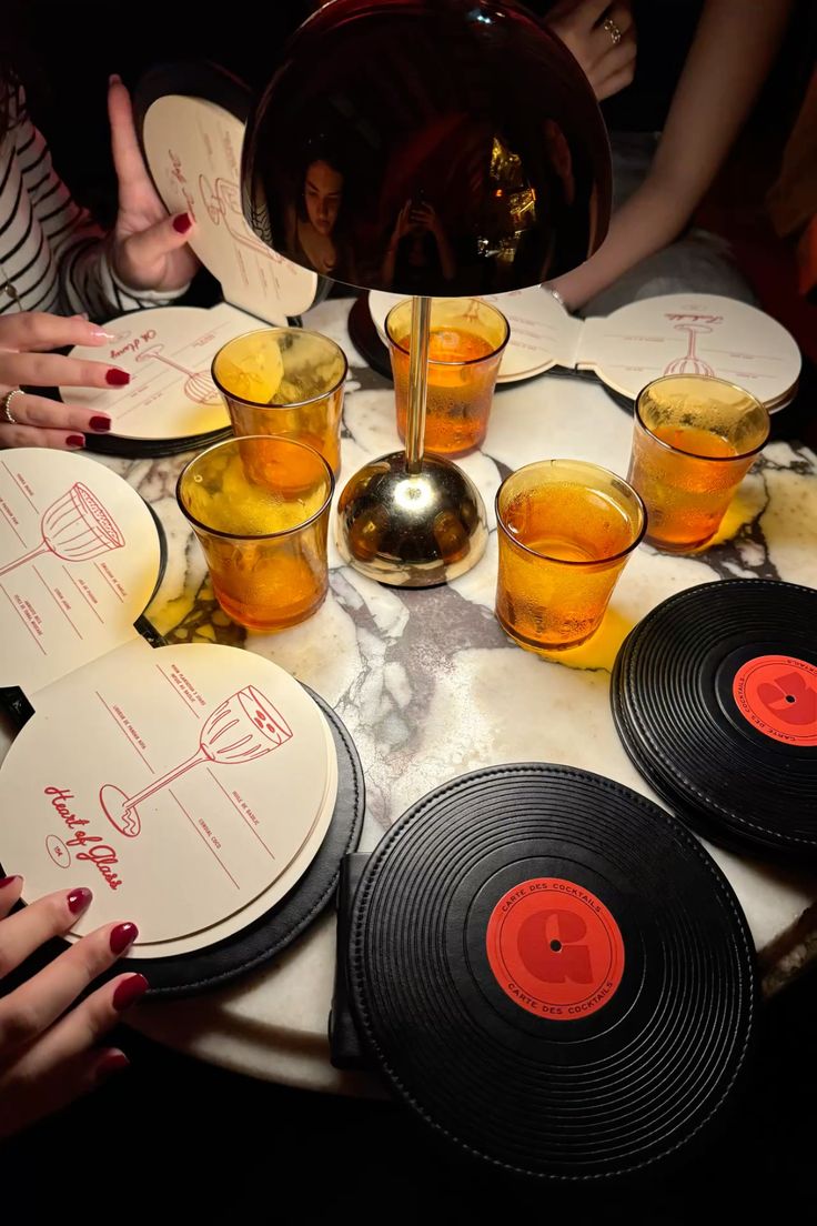 Card&aacute;pios circulares e porta-copos em disco de vinil sobre mesa de m&aacute;rmore