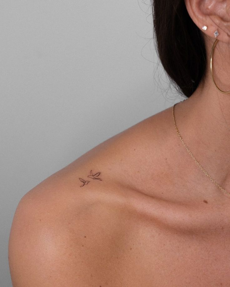 Dois pássaros em fine line no ombro, minimalismo e elegância em uma só tatuagem