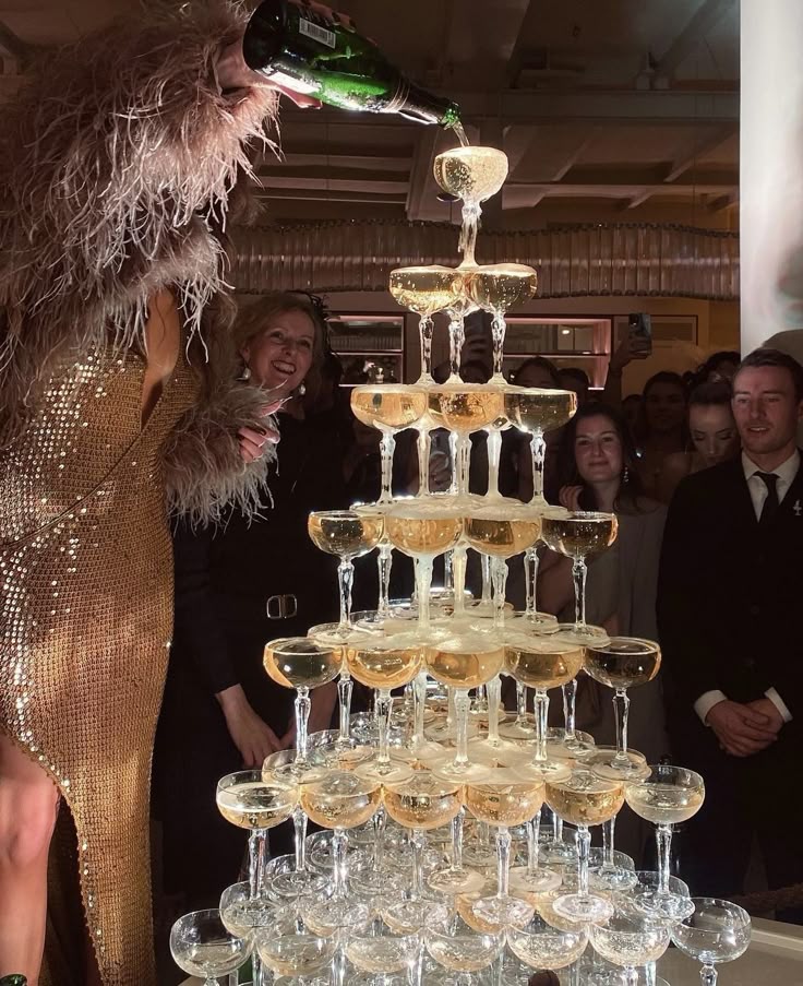 Torre de ta&ccedil;as coupe com champanhe sendo derramado em cascata