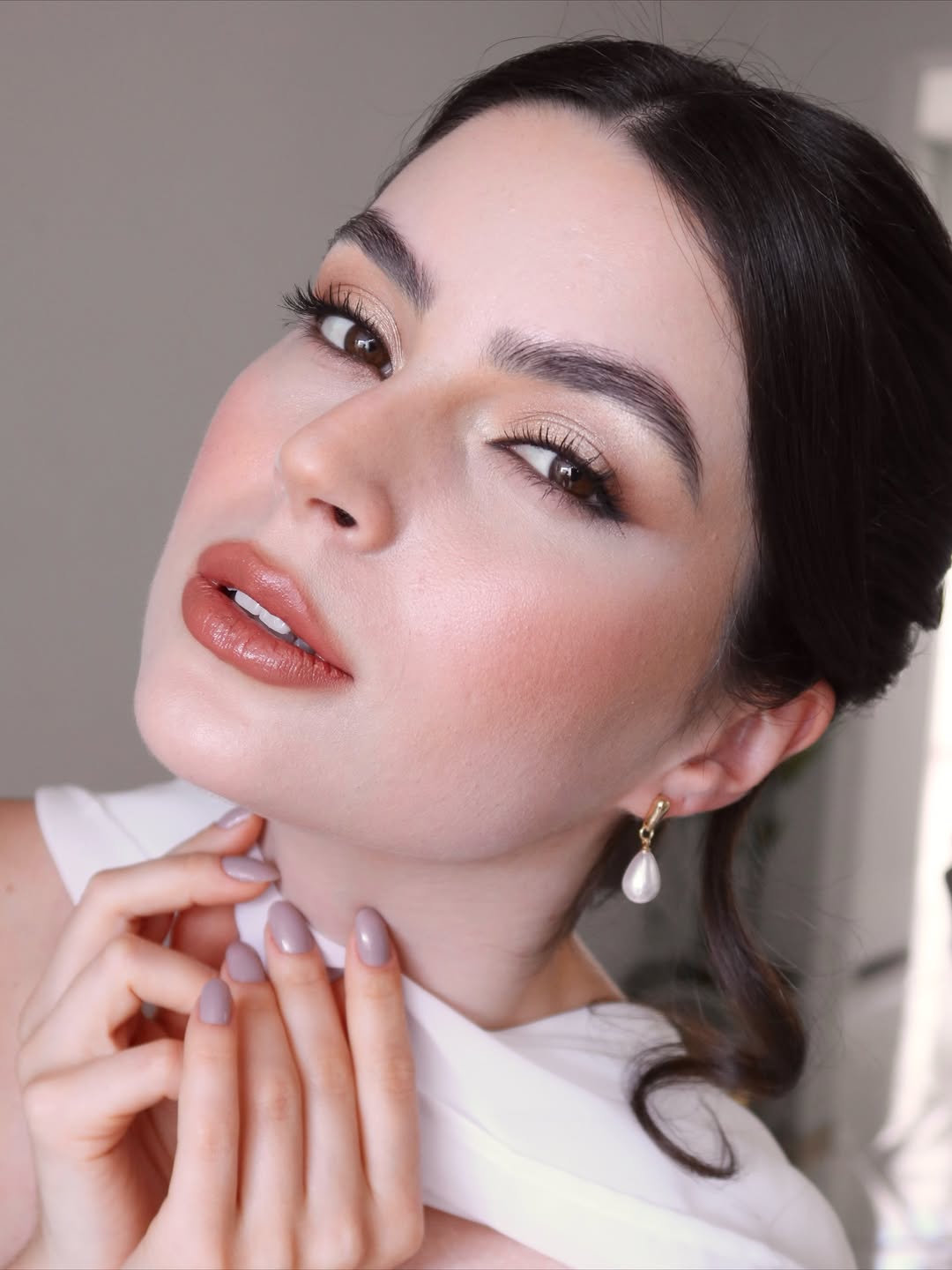 Foto de uma mulher branca, com cabelo preto, e maquiagem leve