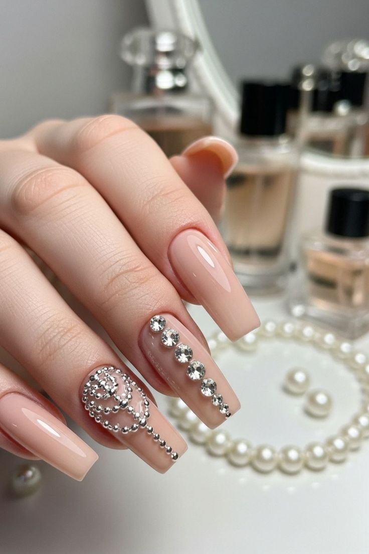 Unhas nude com cristais e strass aplicados, nail art luxuosa com brilho intenso e acabamento elegante