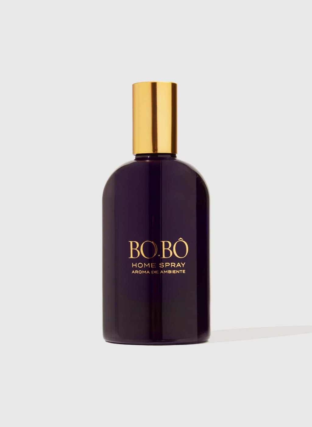 Frasco de spray de ambiente BO.B&Ocirc; roxo escuro com tampa dourada, centralizado em fundo branco. O r&oacute;tulo dourado diz BO.B&Ocirc; HOME SPRAY AROMA DE AMBIENTE