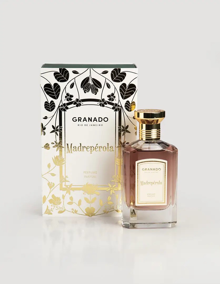 Frasco de perfume Granado Madrep&eacute;rola com l&iacute;quido marrom-rosado e tampa dourada, ao lado de sua caixa branca com detalhes florais pretos e dourados