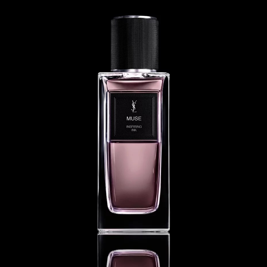 Frasco retangular de perfume Yves Saint Laurent Muse Inspiring Ink, com l&iacute;quido rosa-p&uacute;rpura e tampa preta texturizada, sobre fundo escuro com reflexo