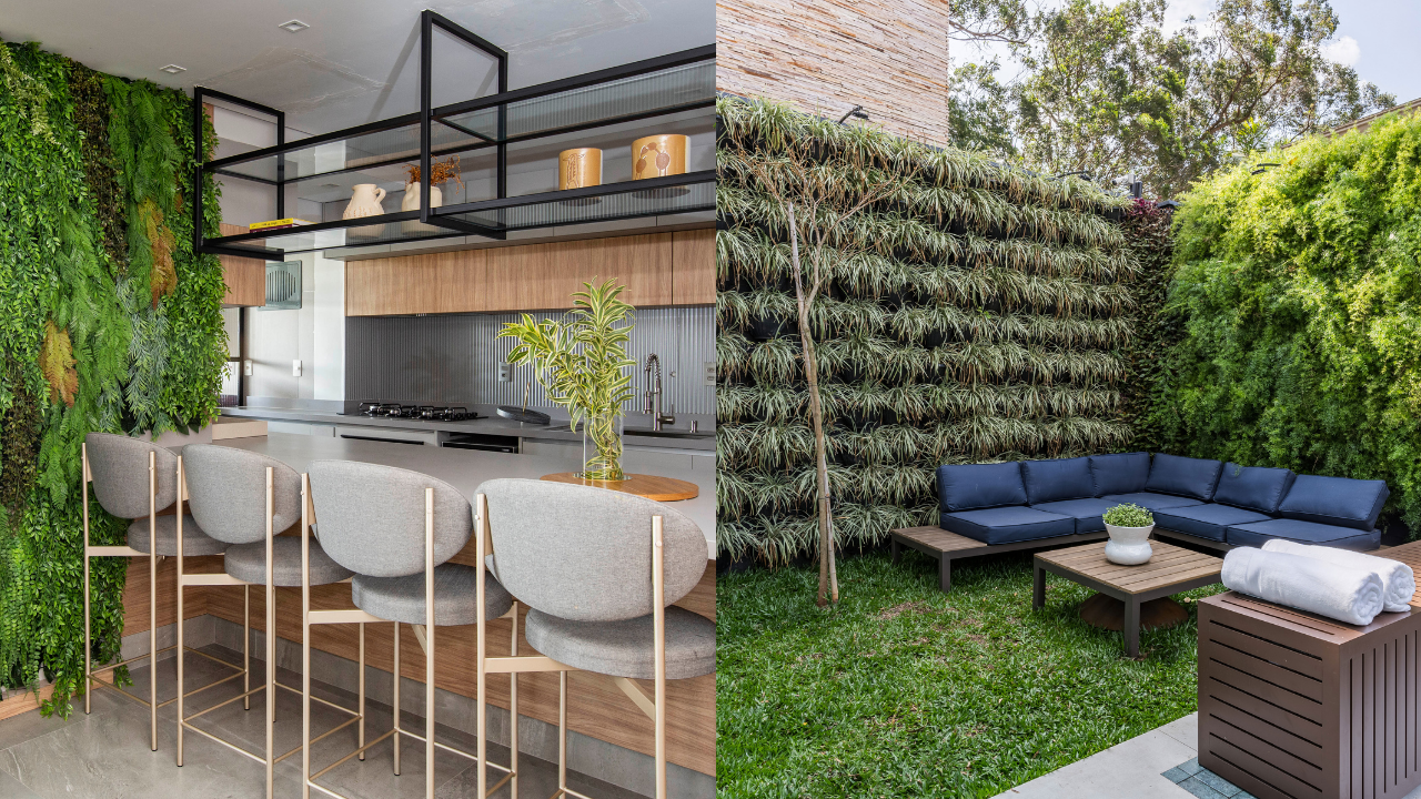 Cozinha moderna com parede verde e bancada com banquetas cinzas, ao lado de um jardim externo com sofá azul em L e parede de plantas