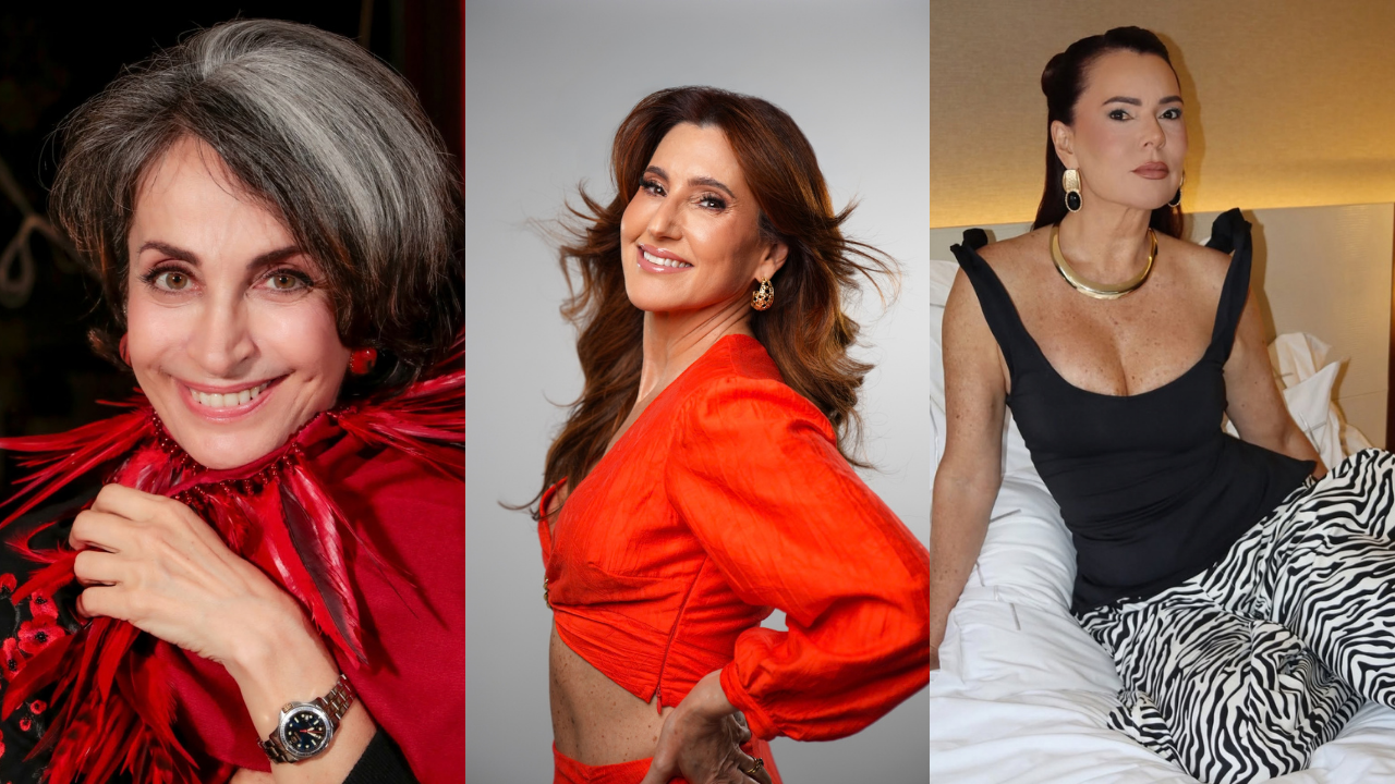 Três mulheres sorrindo em poses diferentes. À esquerda, uma mulher de cabelos grisalhos e escuros, usando um colar de penas vermelhas e um relógio. No centro, uma mulher de cabelos castanhos esvoaçantes, vestindo um top cropped laranja. À direita, uma mulher de cabelos presos, com colar dourado, blusa preta e calça estampada de zebra, sentada em uma cama